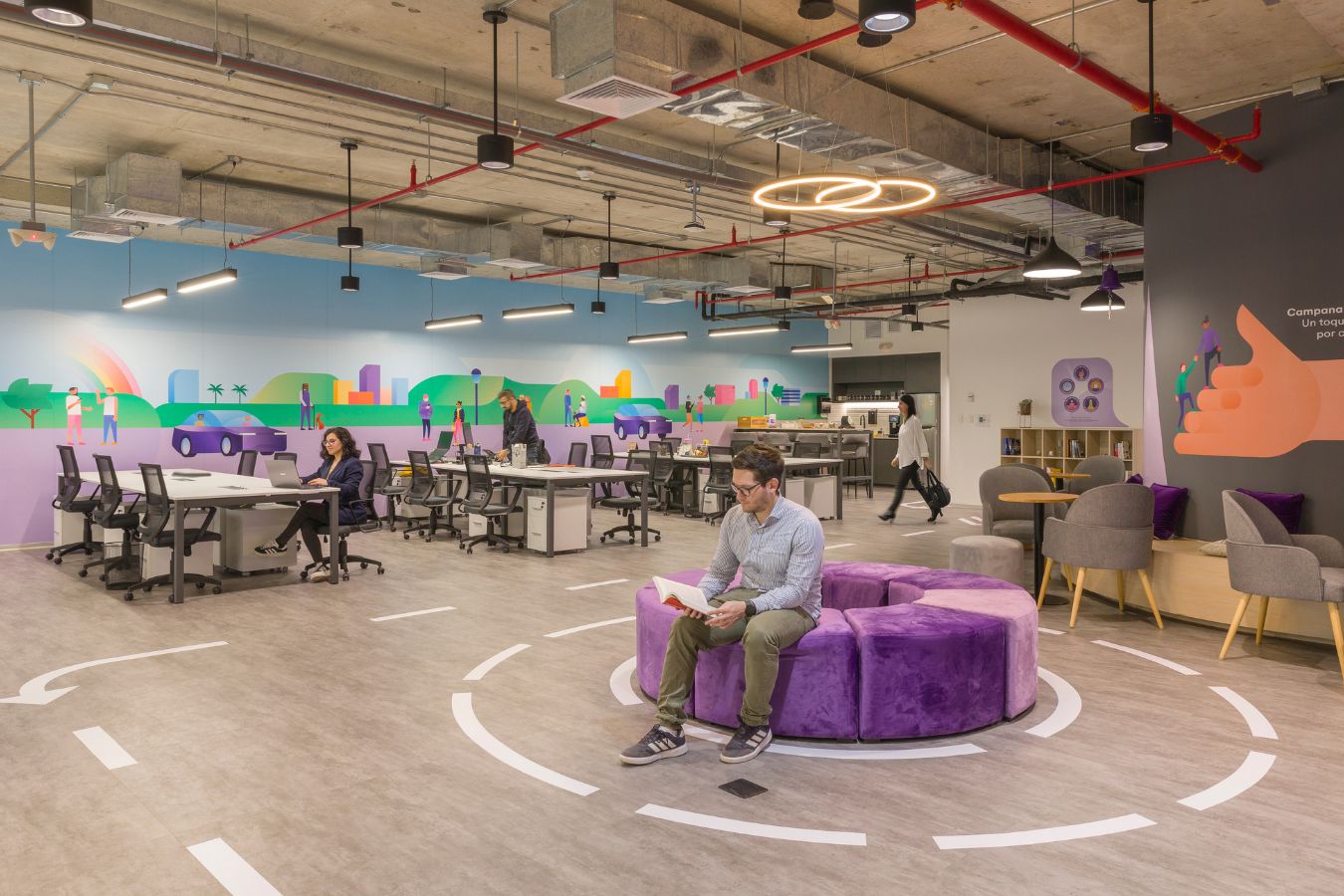 Cabify Offices - Agile work zone with circular purple seating and custom wall murals - Contract Workplaces.jpg